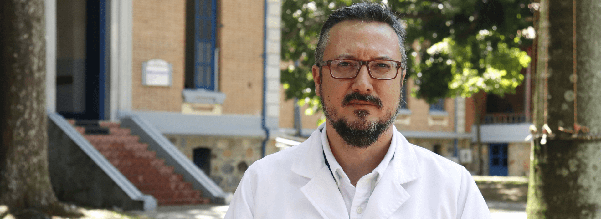 Hombre con bata blanca parado en un lugar