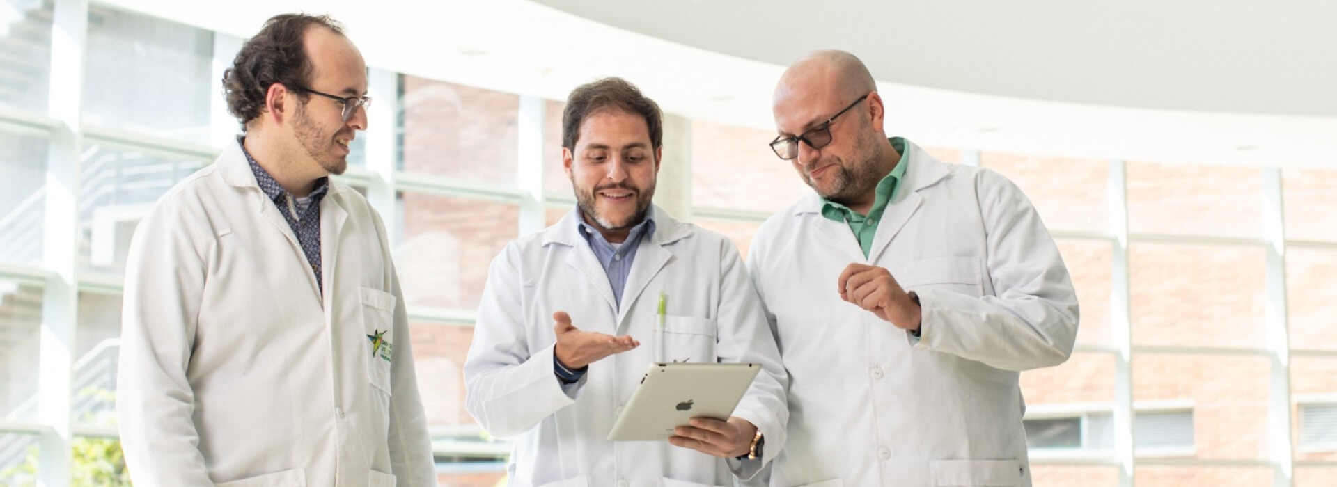 Doctores reunidos señalando una tablet