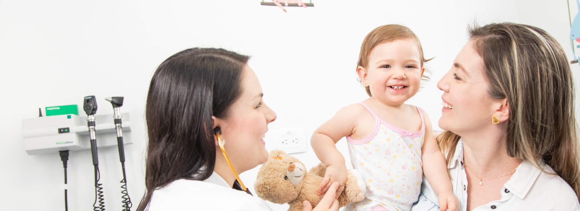 Dos mujeres cargando una niña en sala de hospital