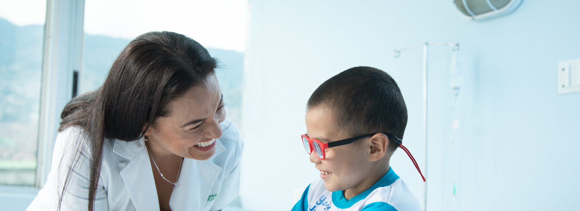 Doctora saludando a niño con gafas
